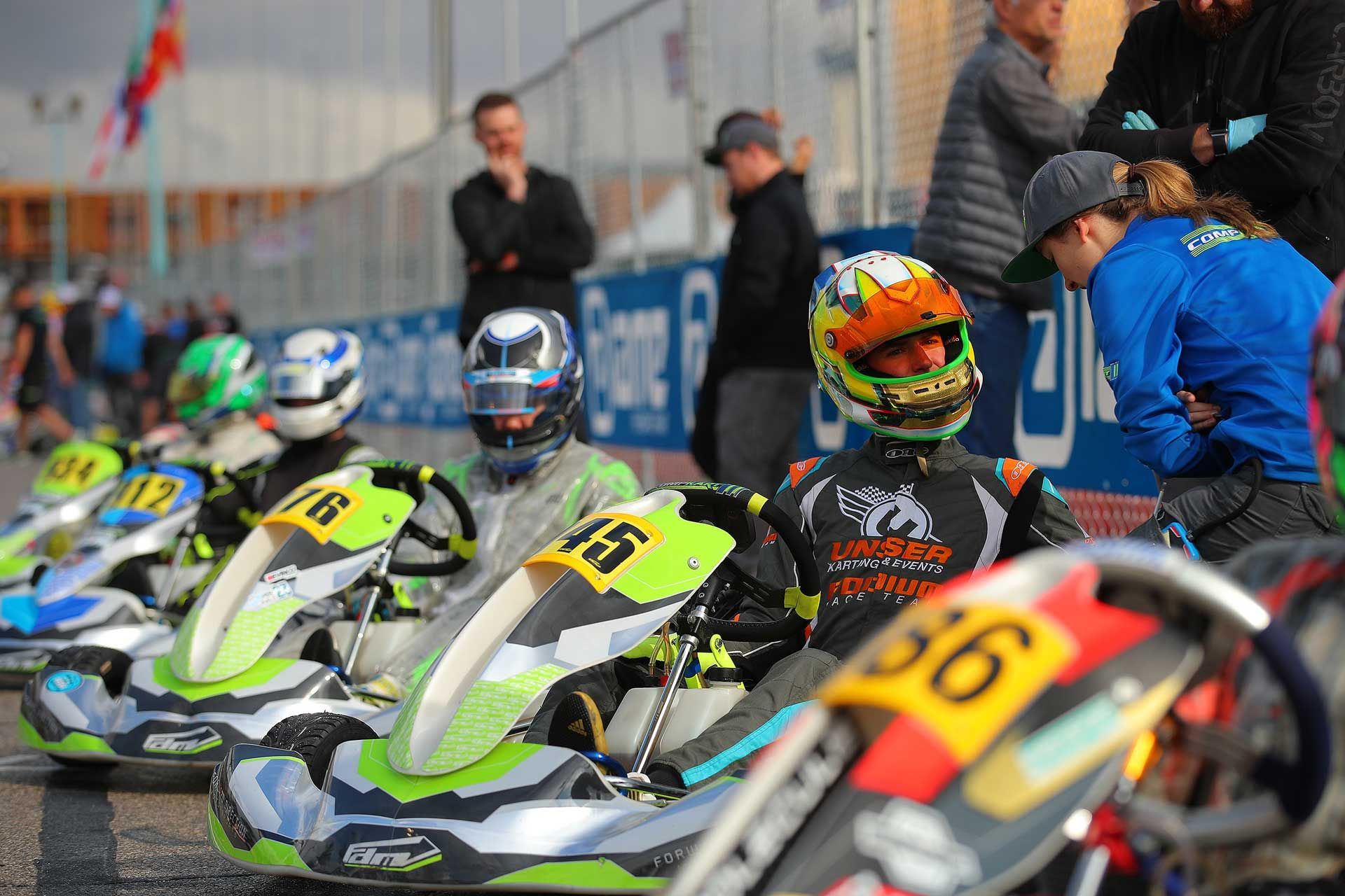 Two people are racing go karts on a track.