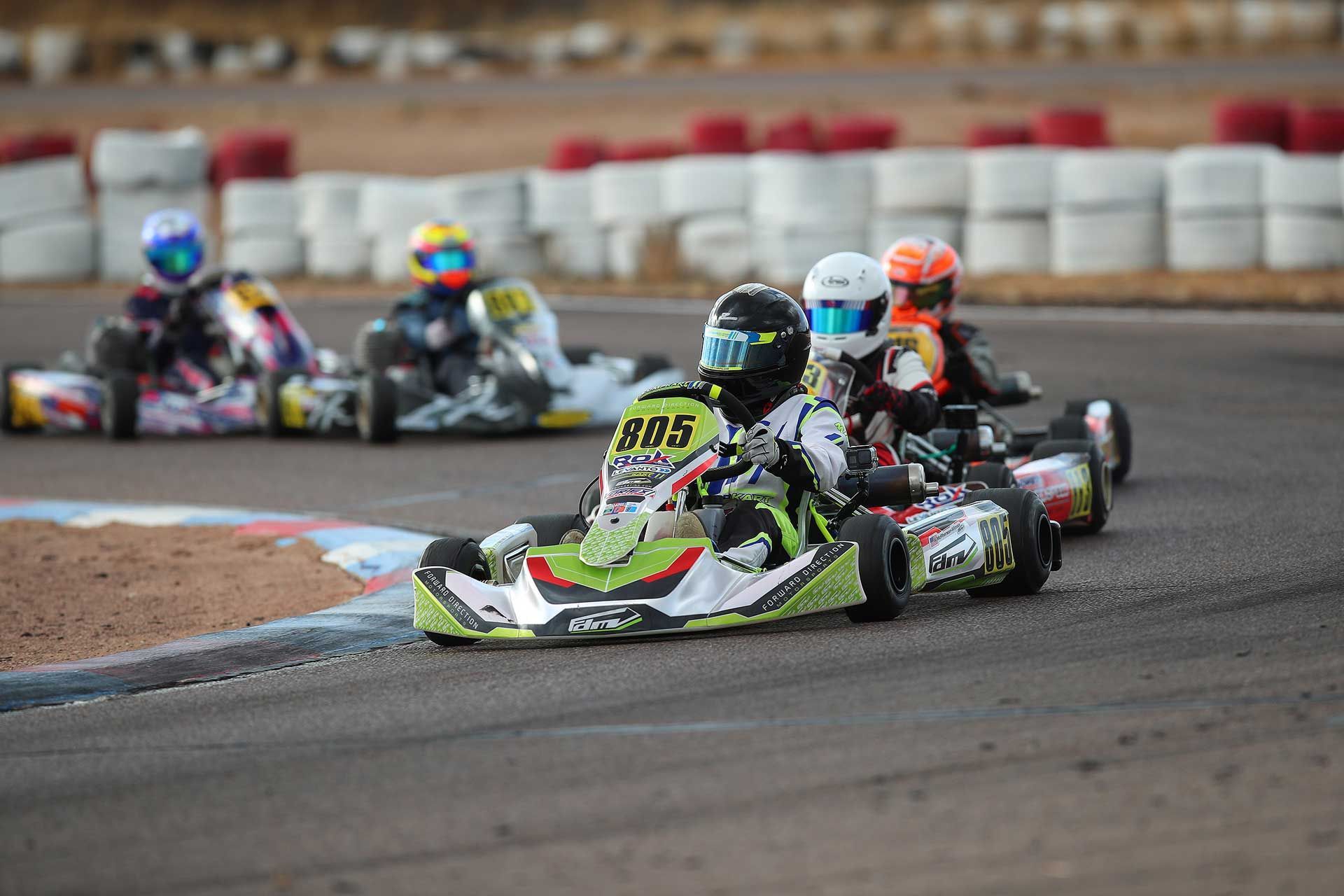 Two people are racing go karts on a track.