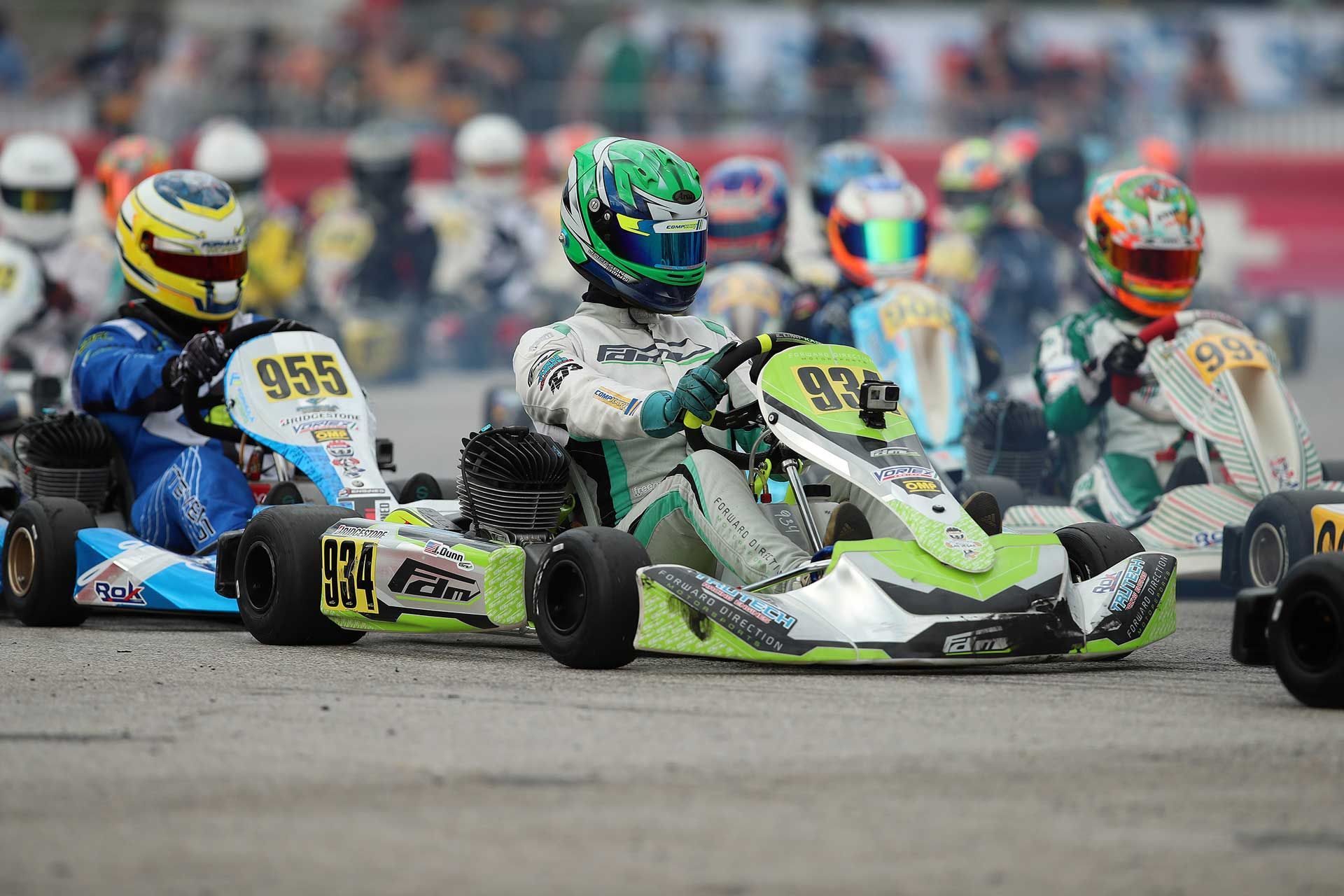Two people are racing go karts on a track.