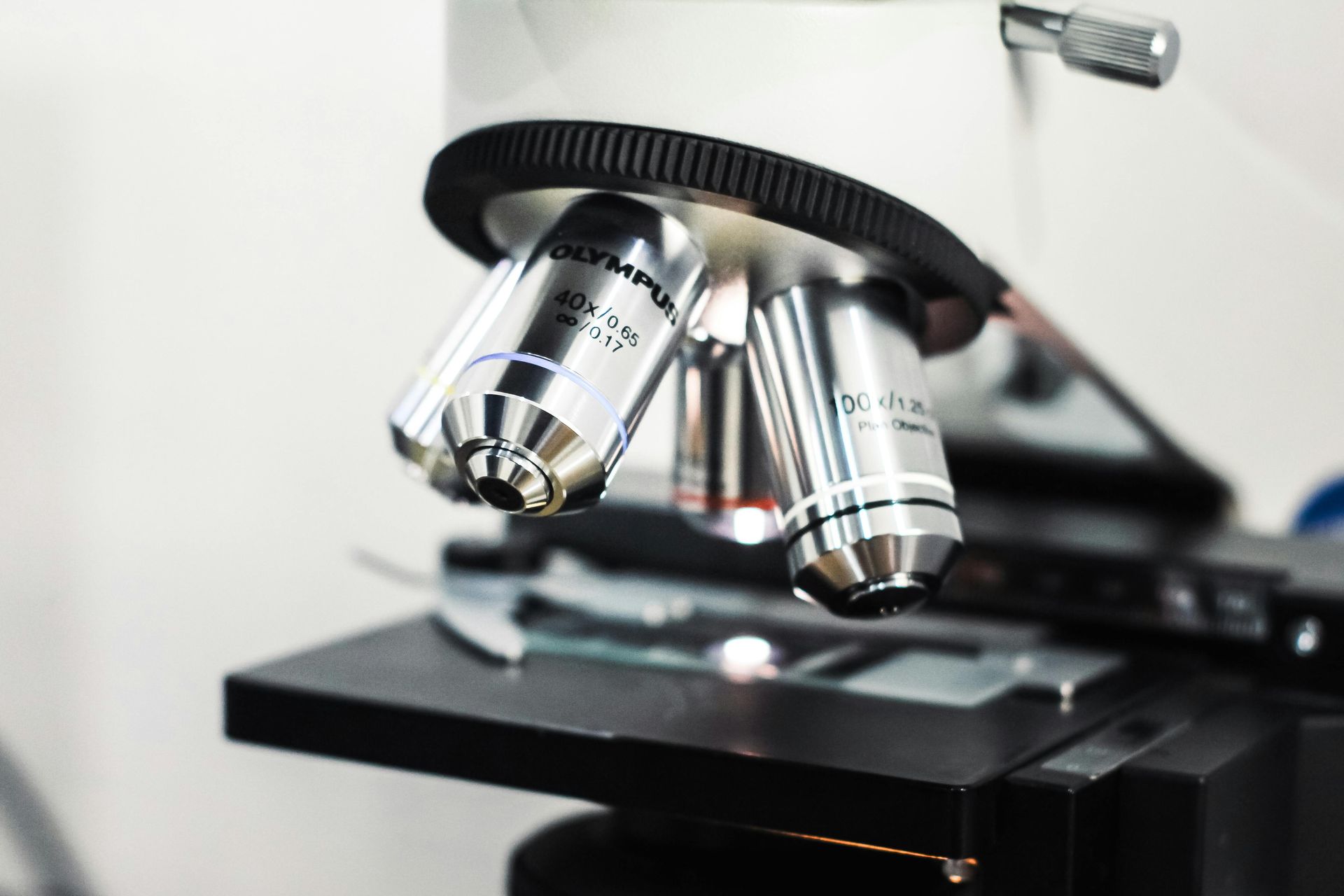 A close up of a microscope with a lot of lenses on it.