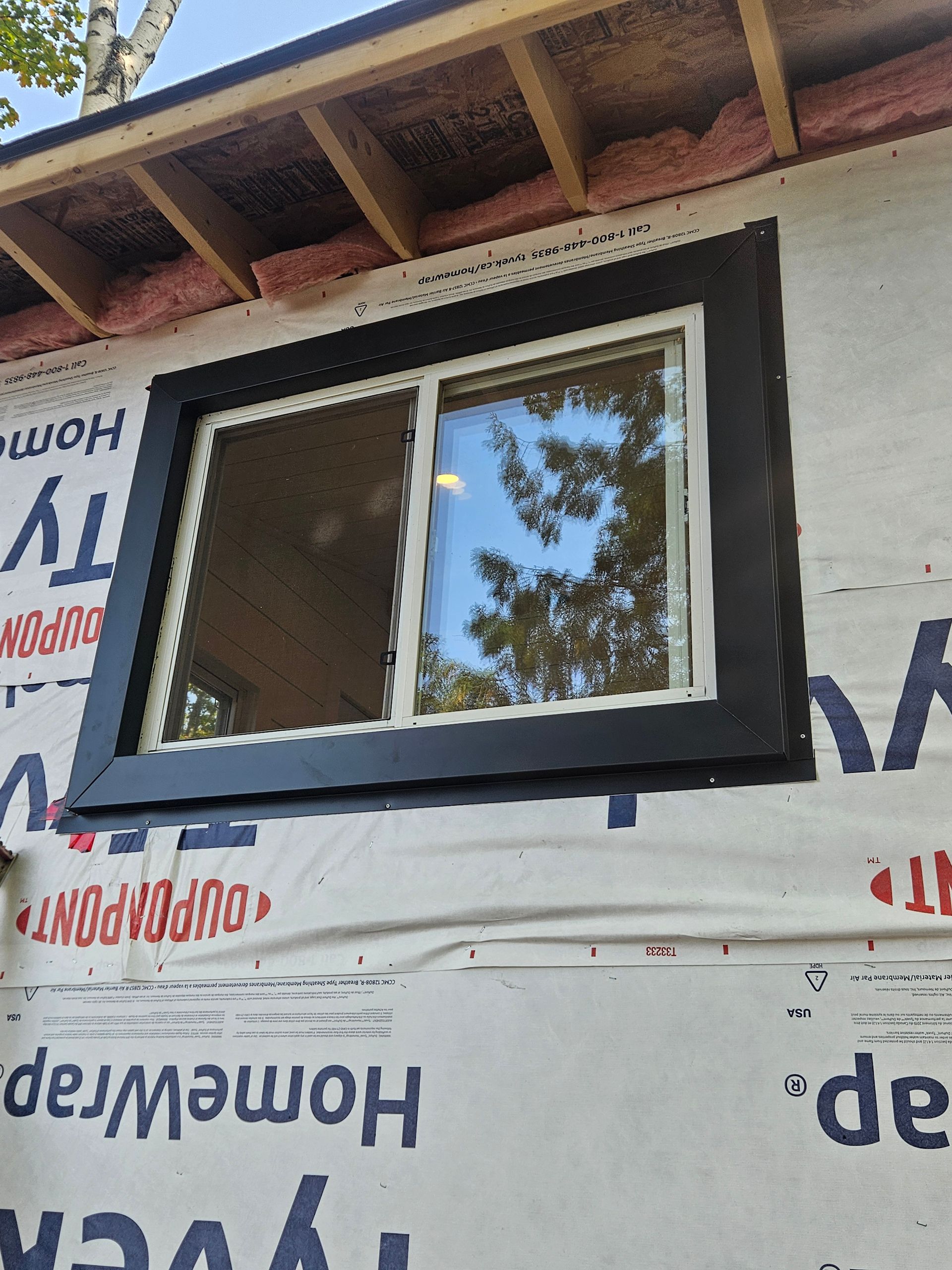 A window is being installed on a house that is being built