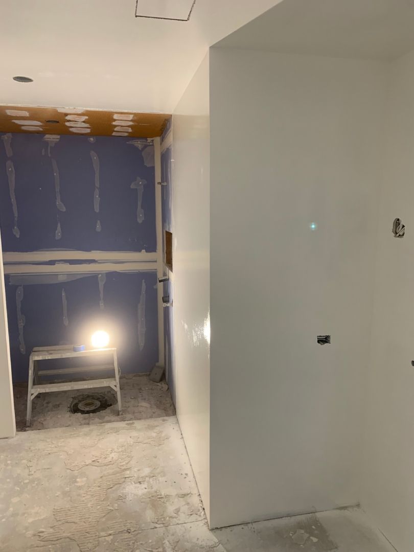A room with white walls and a light on the wall.