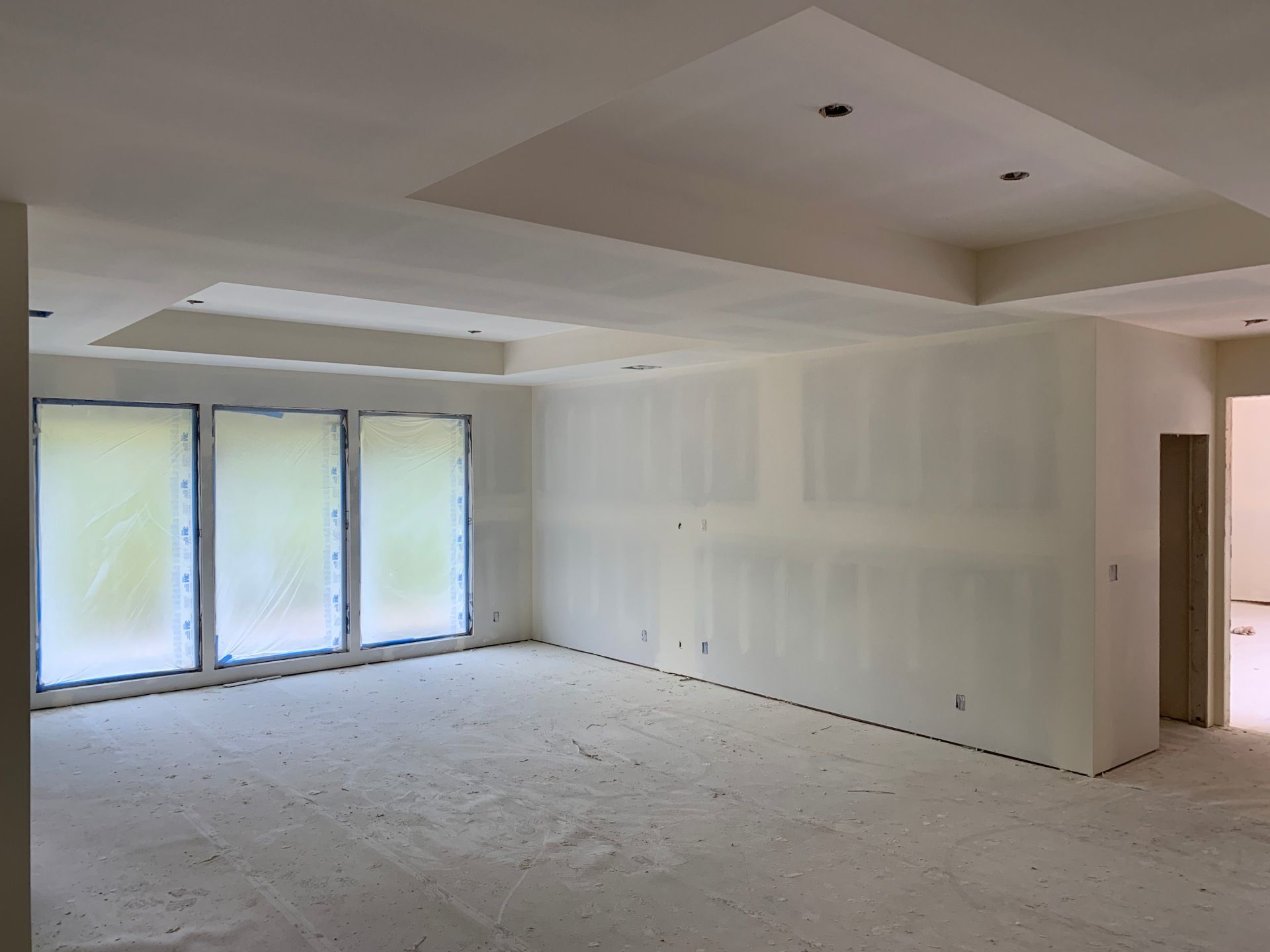 An empty room with drywall on the walls and ceiling.