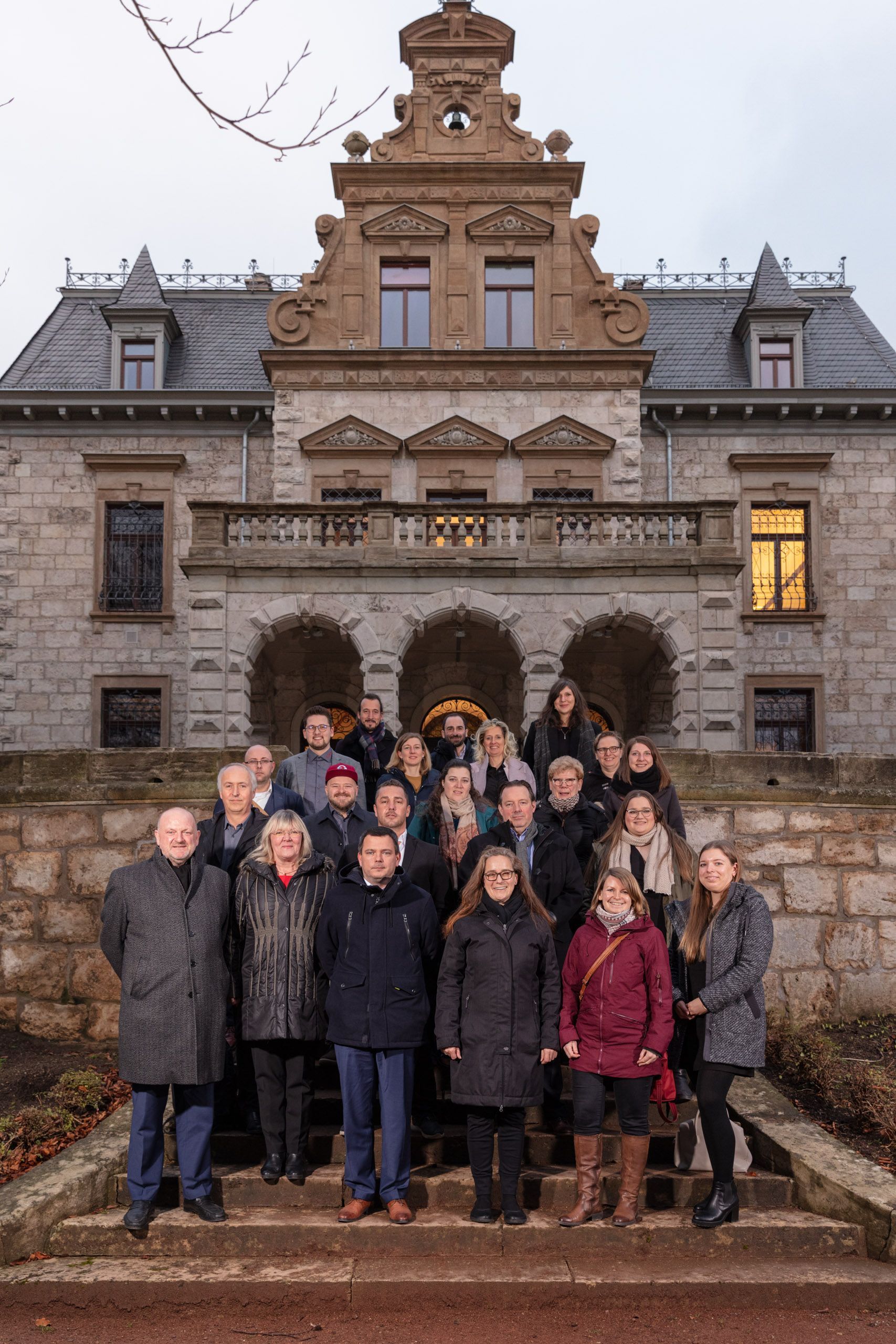 KUKM Teamevent: Teamfoto auf der Treppe zum Eingang der Villa Haar