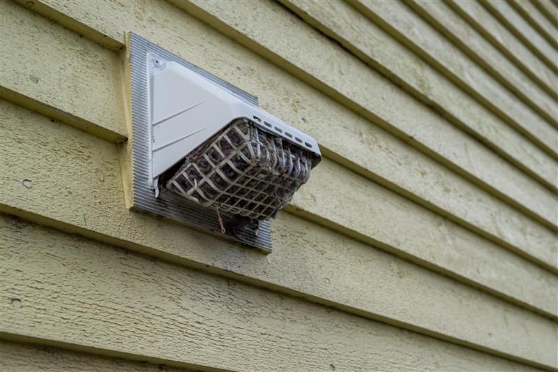 White dryer vent on yellow siding.