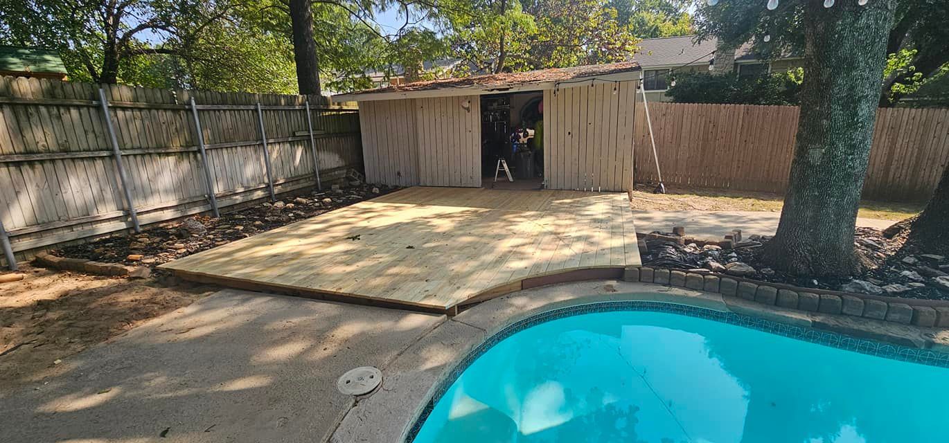Backyard patio with a shed, tree, and blue swimming pool in the foreground