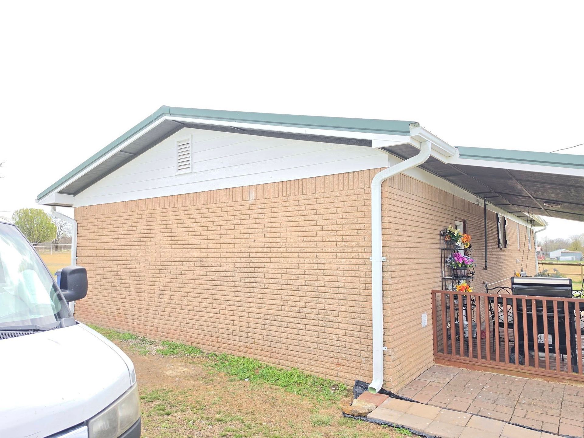Brick house exterior with white trim, gutter, and small front porch