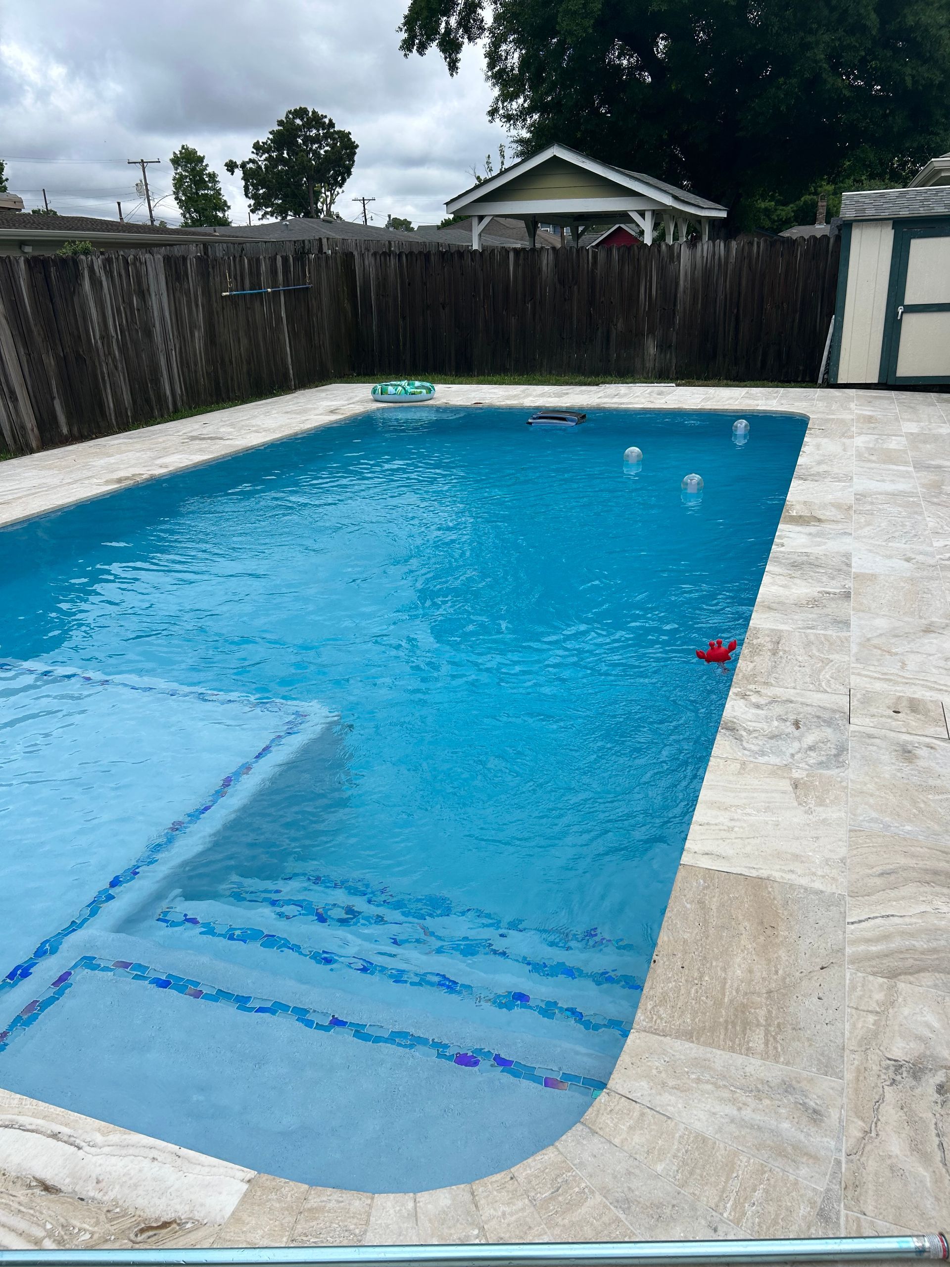 A large swimming pool with a fence in the background