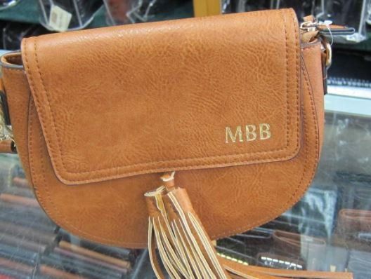 Brown leather crossbody bag with tassel and monogram 