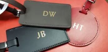 Two luggage tags with the initials dw and jb on them