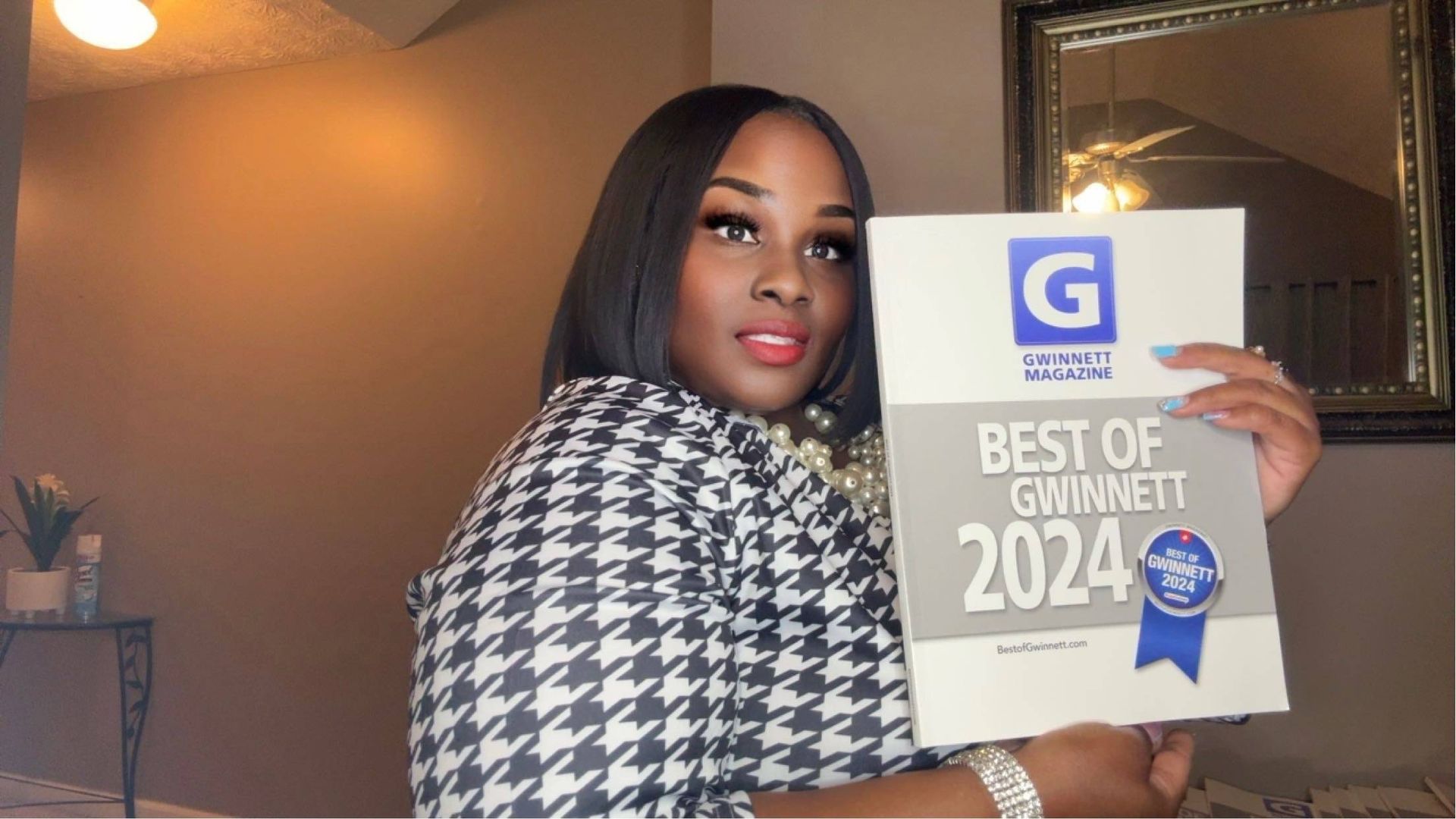A woman is holding a sign that says best of gwinnett 2024.