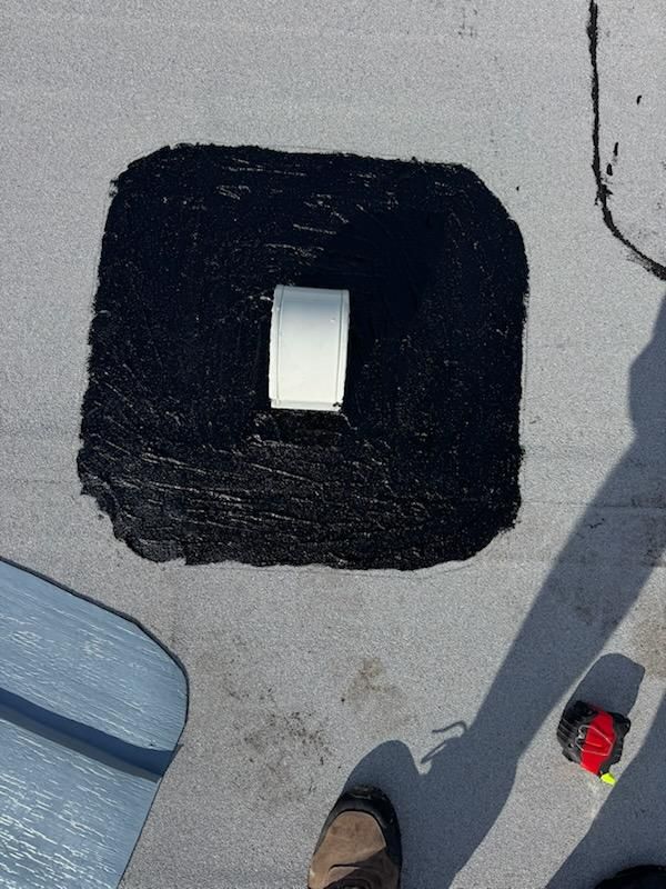 Black square mat on a gray floor with a white rectangular opening in the center.
