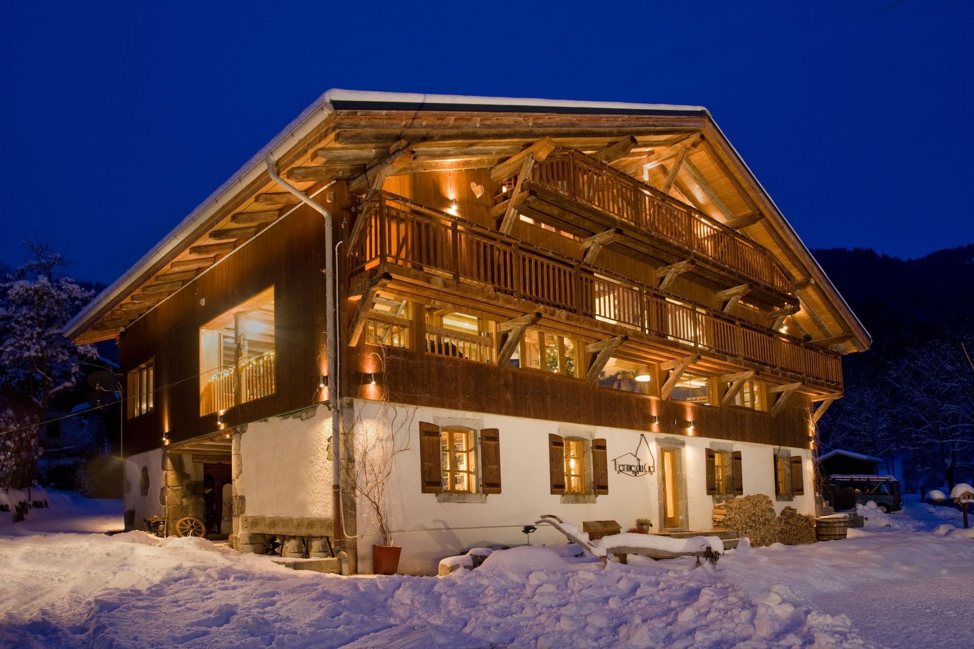 Snowy alpine chalet glowing warmly at night under a blue sky