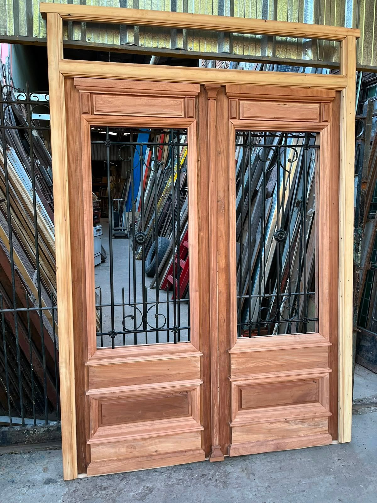 Puertas dobles de madera con paneles de vidrio ubicadas en un taller o aserradero.