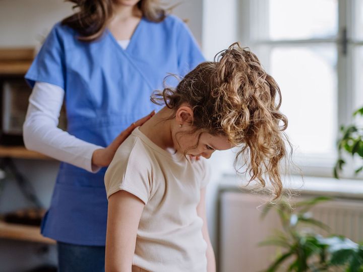 Chiropractor examining a child for a pediatric consultation