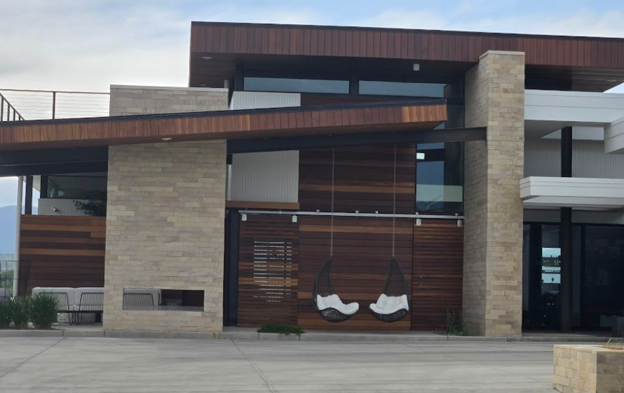 Modern building exterior with stone pillars, wood panels, and large windows
