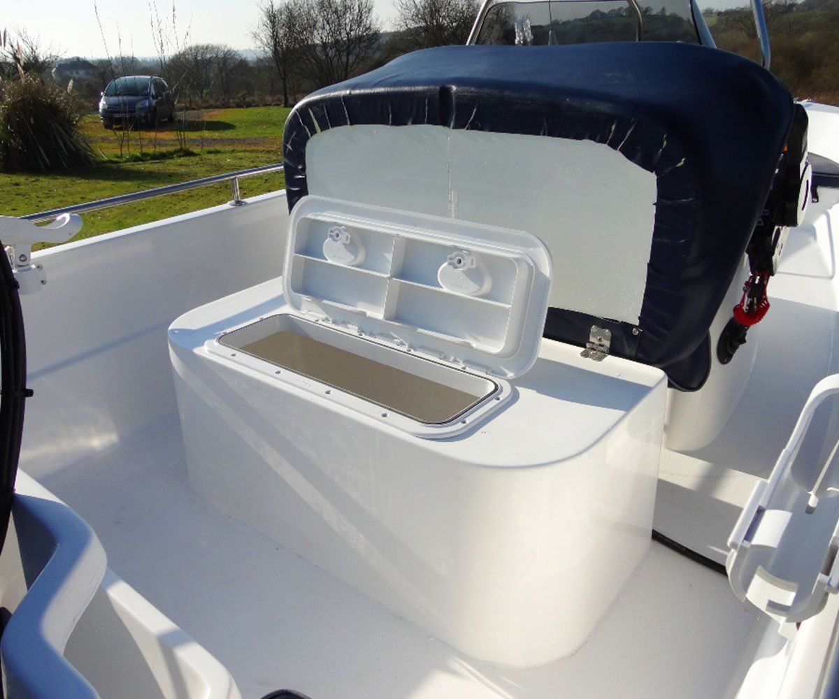 White boat interior with open storage compartment and dark blue cover.