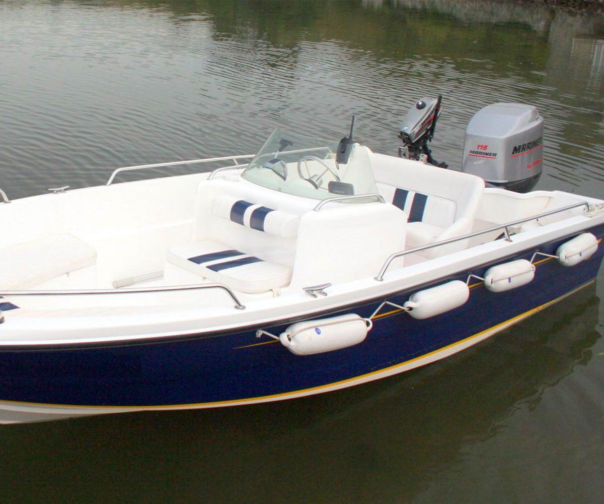 Blue and white motorboat with an outboard motor docked on the water.