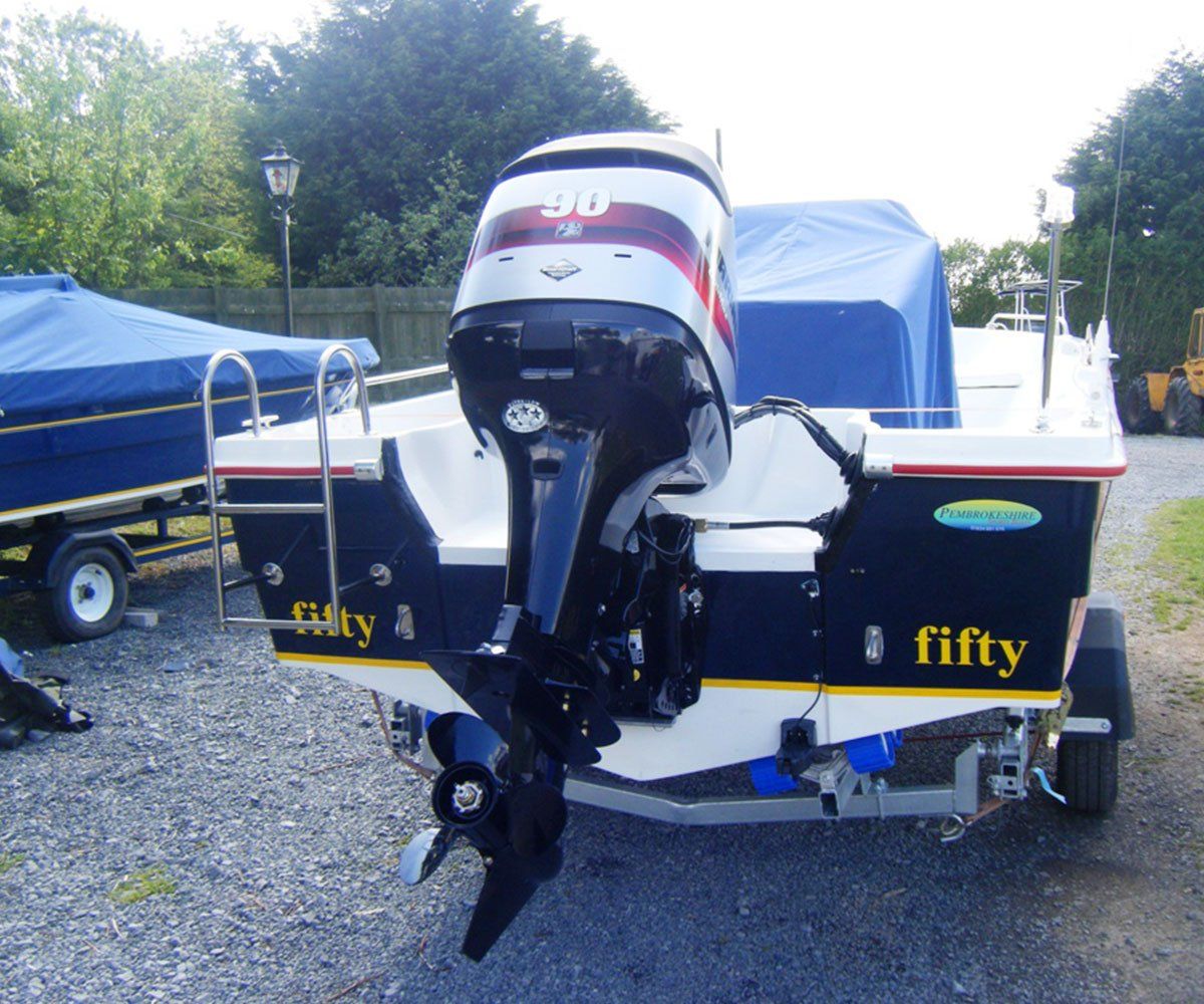 A white motorboat with a black engine and the word 