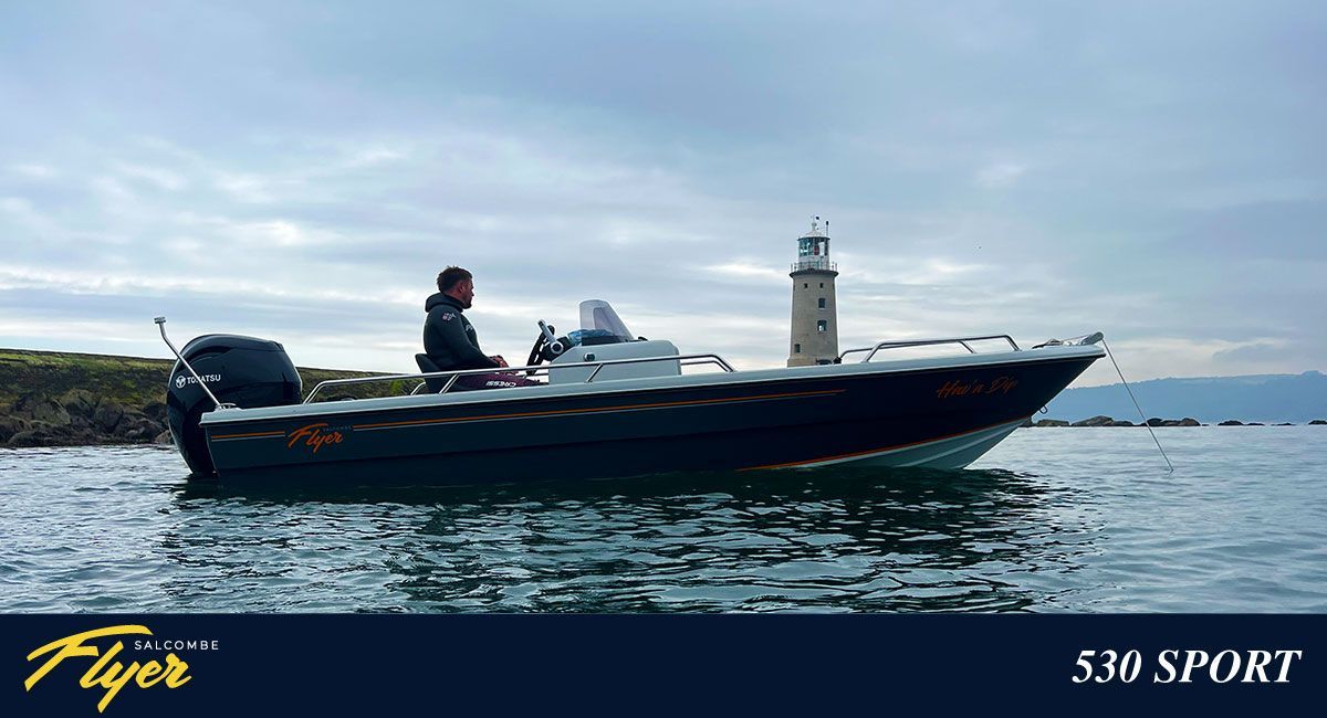 Boat on water with a person, lighthouse in the background. Blue boat and sea, overcast sky.