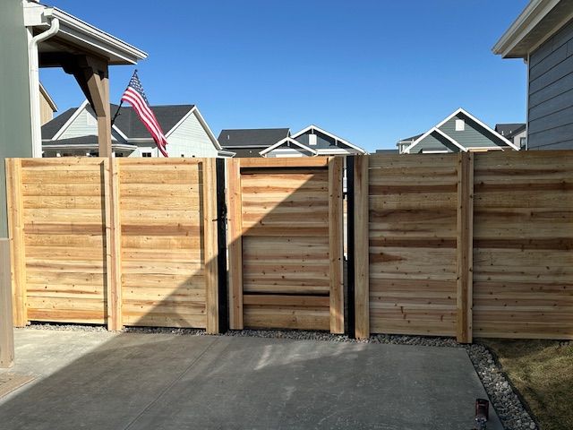 A wooden fence with an american flag in the background
