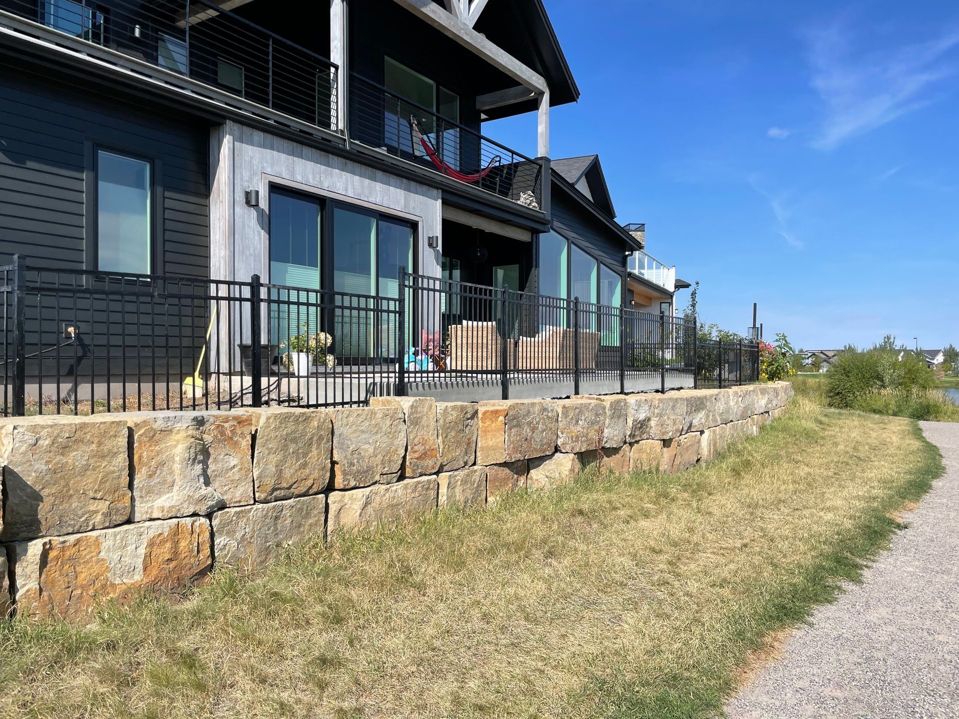 A large house with a stone wall in front of it.