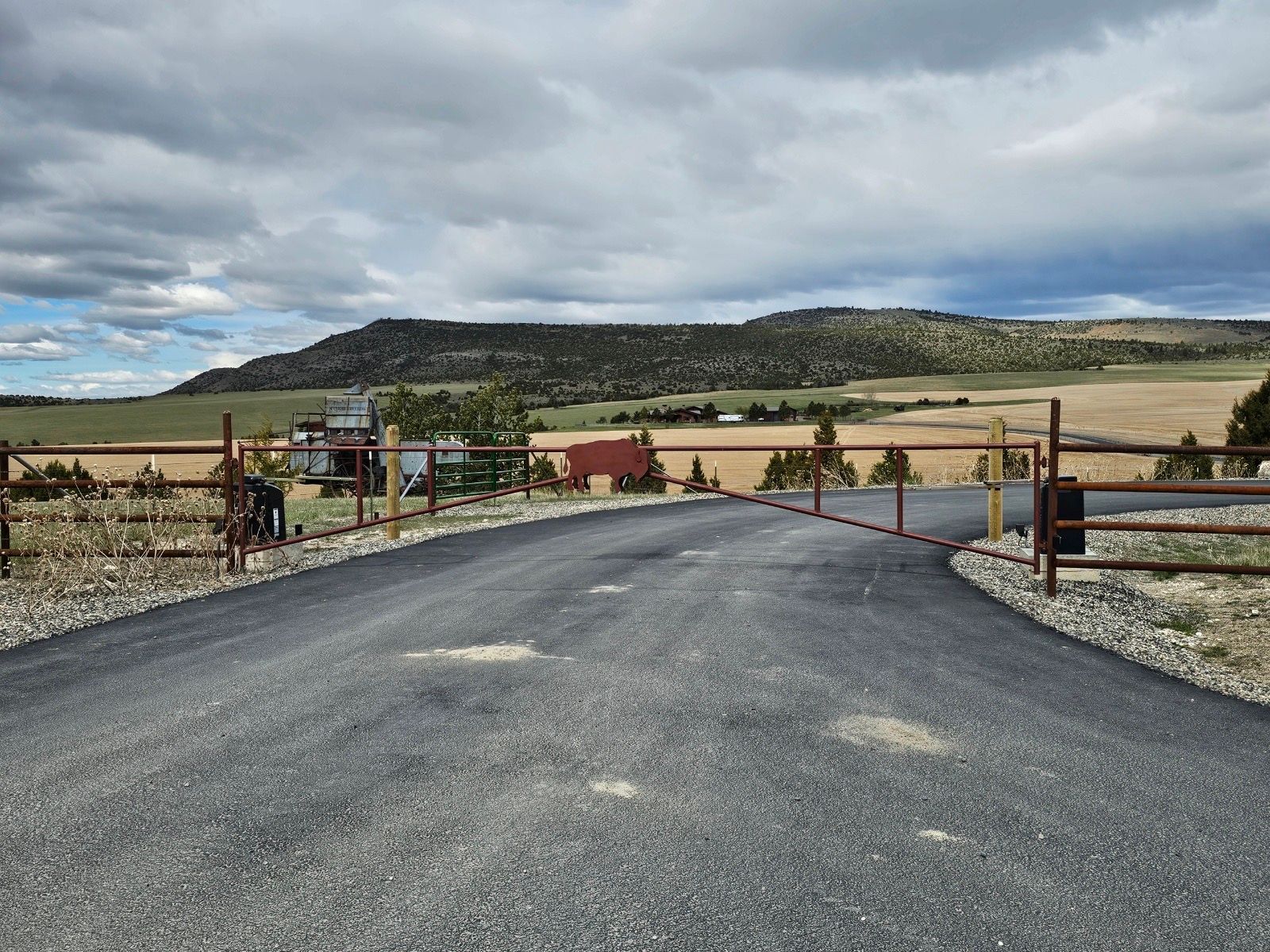 A road with a wooden fence and mountains in the background