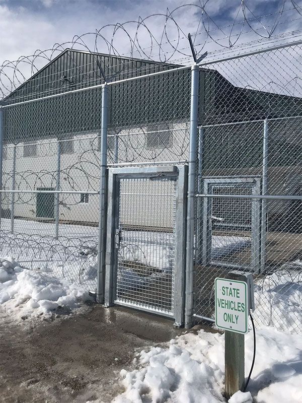 A barbed wire fence with a gate and a sign that says state vehicles only.