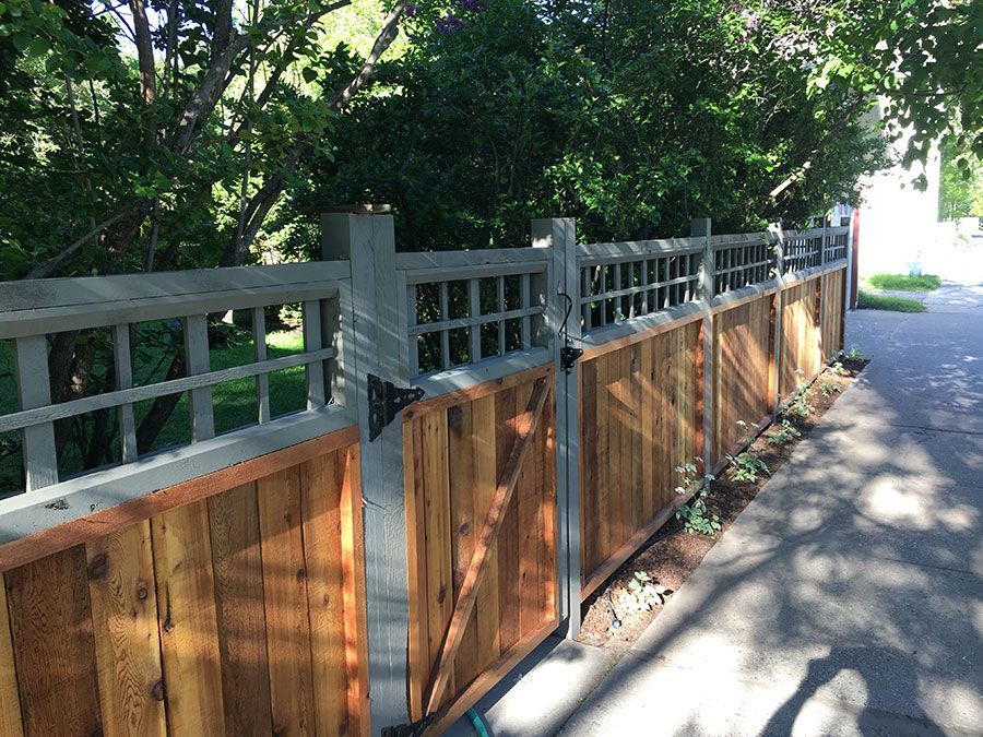 A wooden fence is sitting on the side of a road.