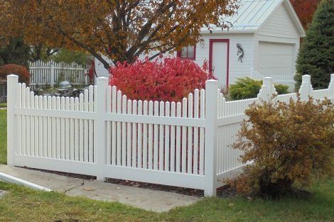 A white picket fence in front of a white house