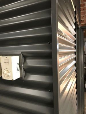 Grey Corrugated Metal Wall With a White Electrical Box — R&M Sheetmetal Nowra Metal Roofing in South Nowra, NSW