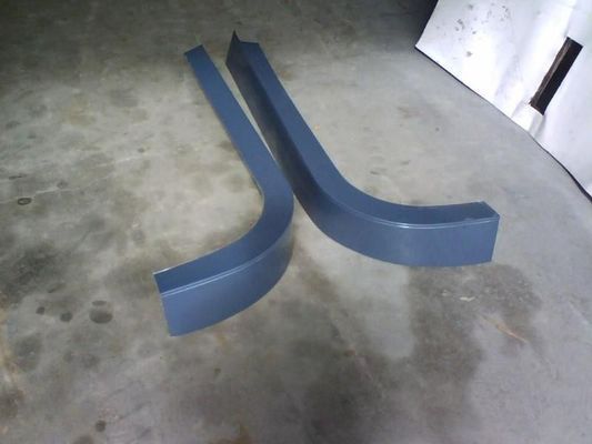 Two Bent, Grey Plastic Car Side Skirts Resting on a Concrete Floor — R&M Sheetmetal Nowra Metal Roofing in South Nowra, NSW