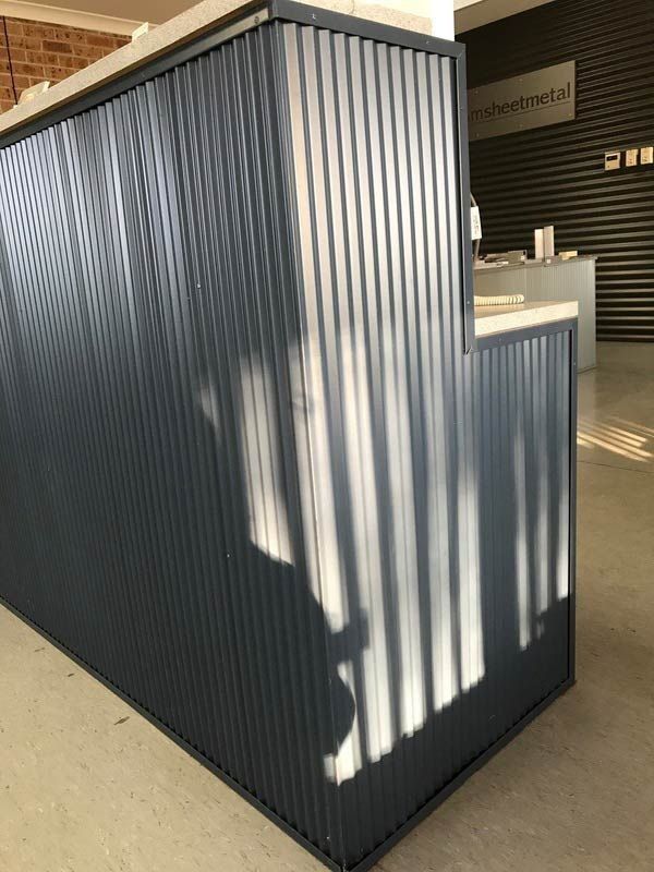 A Metal Wall with A Shadow of A Person on It — R&M Sheetmetal Nowra Metal Roofing in Kiama, NSW