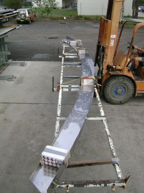 A Forklift Is Carrying a Large Piece of Metal in A Parking Lot — R&M Sheetmetal Nowra Metal Roofing in South Nowra, NSW