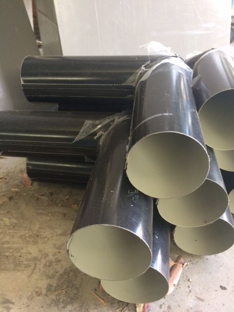 Black metal pipe fittings stacked on a light-coloured surface. — R&M Sheetmetal Nowra Metal Roofing in South Nowra, NSW