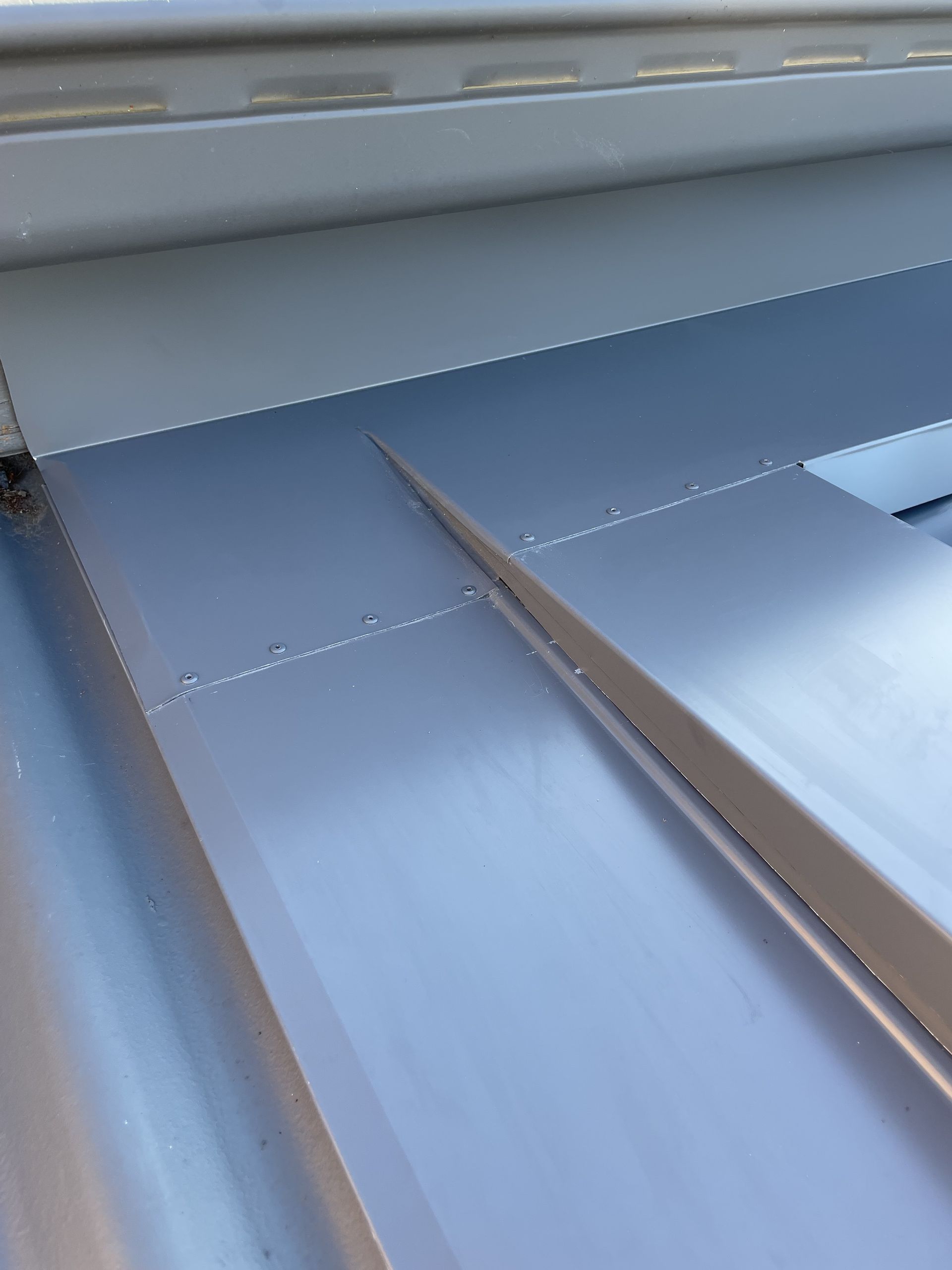 Close-up view of a grey metal roof, showing overlapping panels and seams. — R&M Sheetmetal Nowra Metal Roofing in South Nowra, NSW