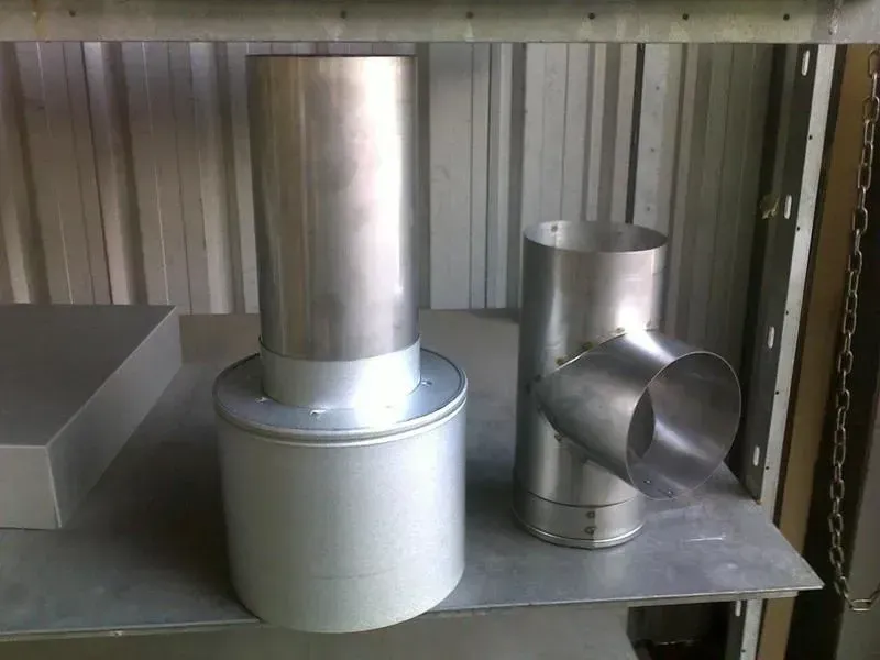 Two silver metal chimney components on a metal shelf. — R&M Sheetmetal Nowra Metal Roofing in South Nowra, NSW