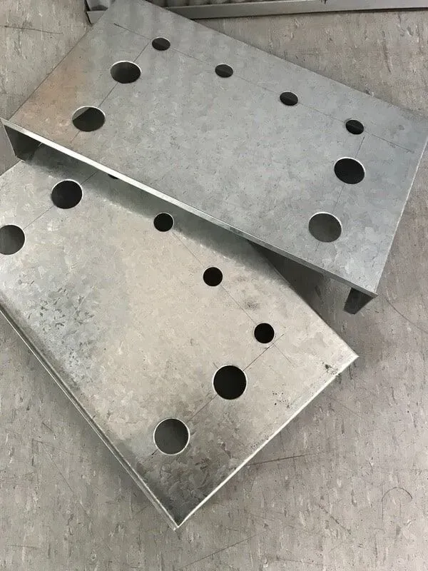 Two galvanized steel mounting plates with drilled holes. — R&M Sheetmetal Nowra Metal Roofing in South Nowra, NSW