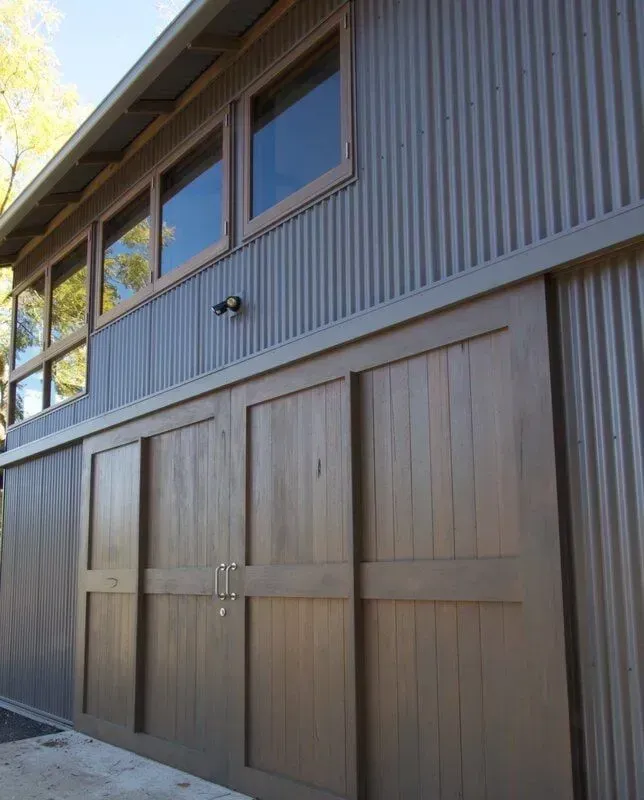 Building Exterior with Corrugated Metal Siding, Wooden Sliding Doors, and Windows — R&M Sheetmetal Nowra Metal Roofing in South Nowra, NSW