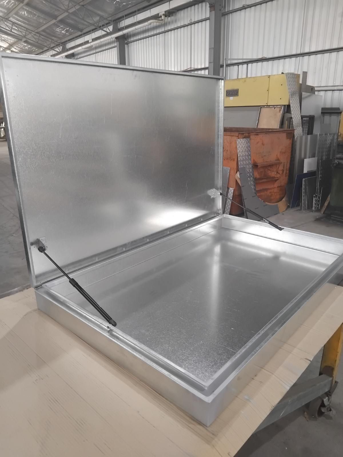 A large metal box is sitting on top of a wooden table in a warehouse. — R&M Sheetmetal Nowra Metal Roofing in South Nowra, NSW