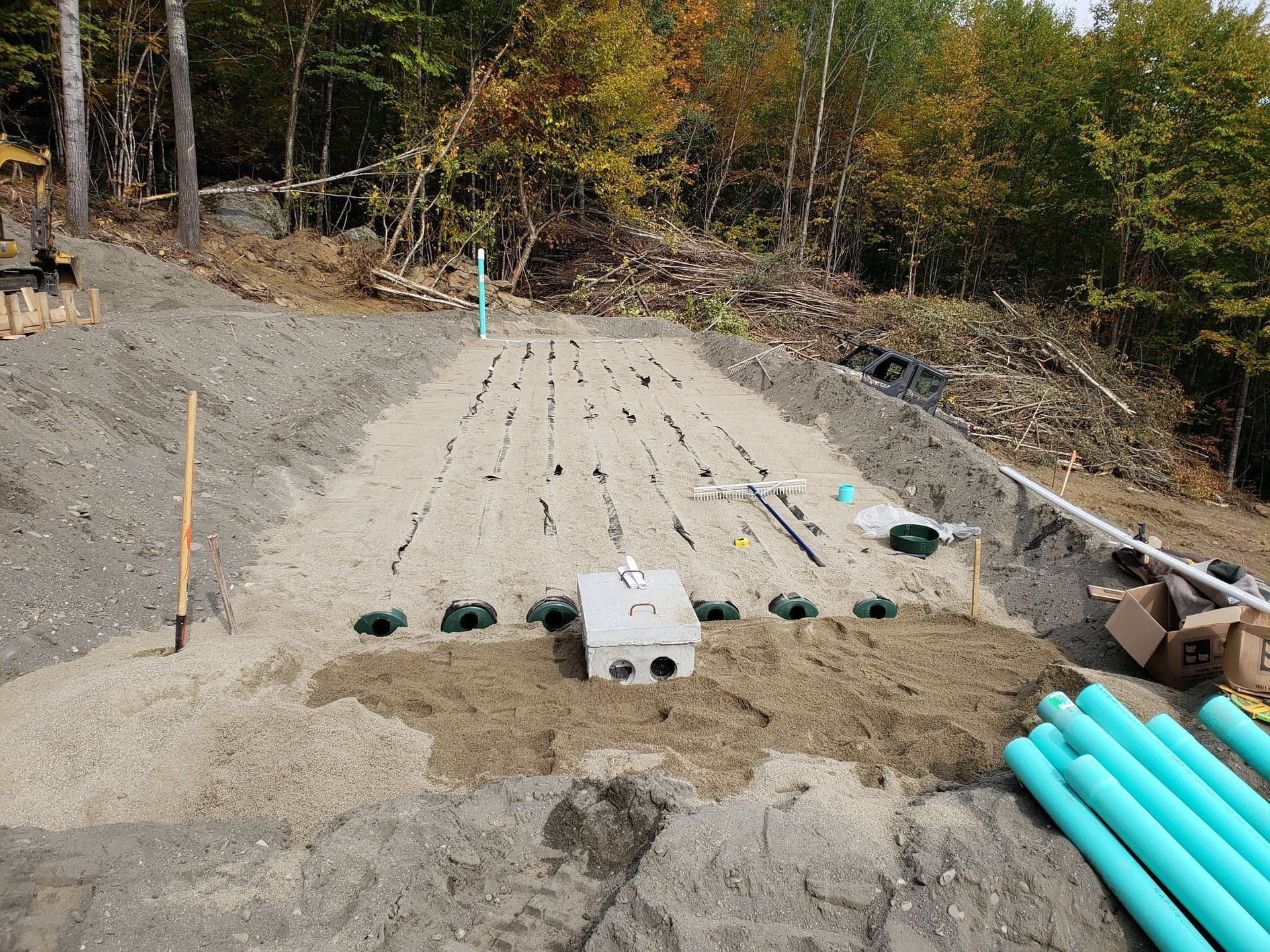 Man inspecting a red propane tank in a trench. Tank is in a dirt area, outdoors.