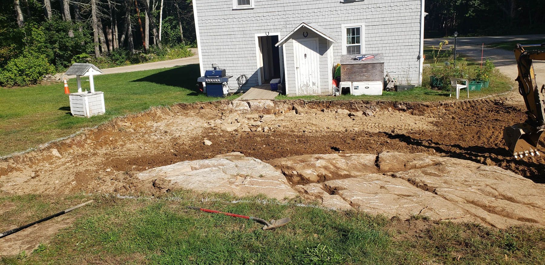 A building with a well and construction on the front lawn.