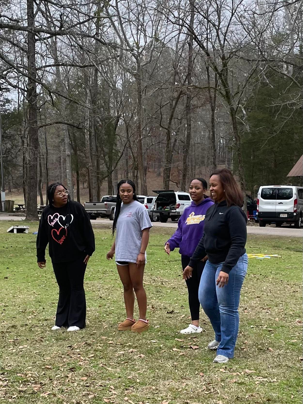 A group of women are standing in a grassy field.