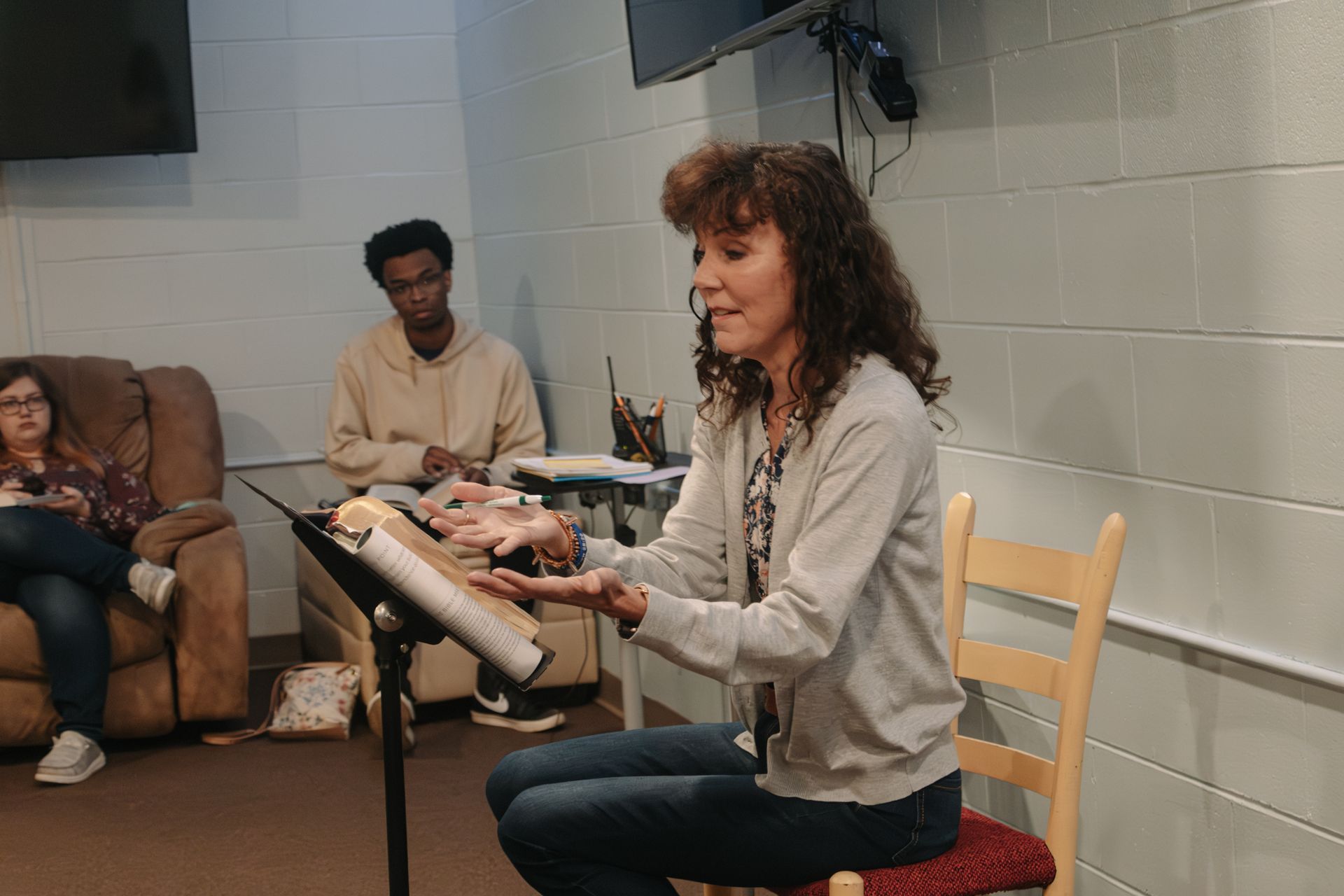 A woman is sitting in a chair holding a piece of paper.