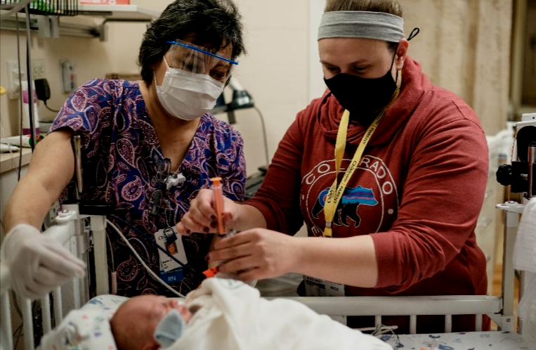 Minnesota nurses caring for newborn baby in hospital nursery