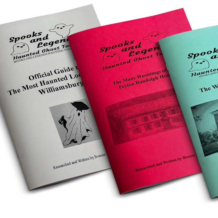 Three colorful ghost tour booklets: gray, red, and turquoise, with ghost and building illustrations.