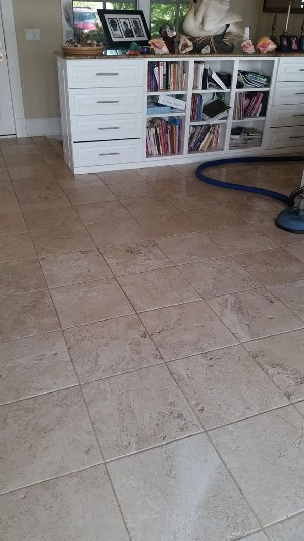 Living room with a white cabinet, tiled floor, and a vacuum hose on the right side.