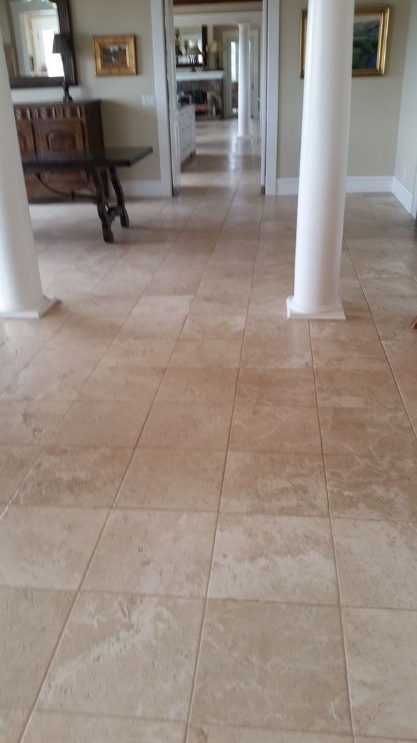 Tiled hallway with white columns and a wooden bench along the left wall