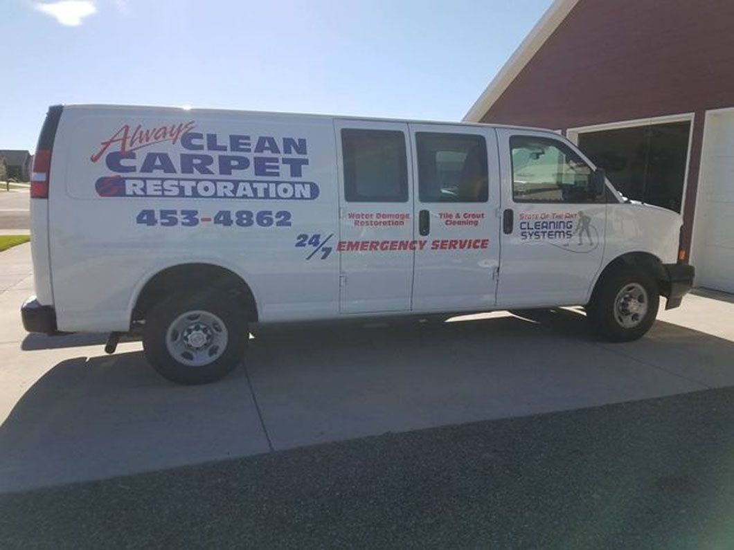 White Clean Carpet Restoration van parked in a driveway with company contact information on the side