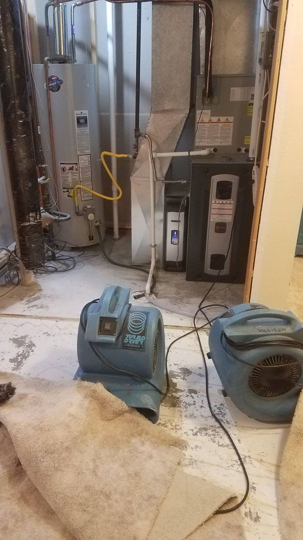 Basement HVAC area with furnace, ductwork, and two blue blower fans on the floor